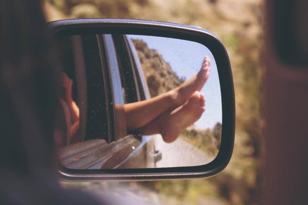 Noore naise jalad auto peeglis